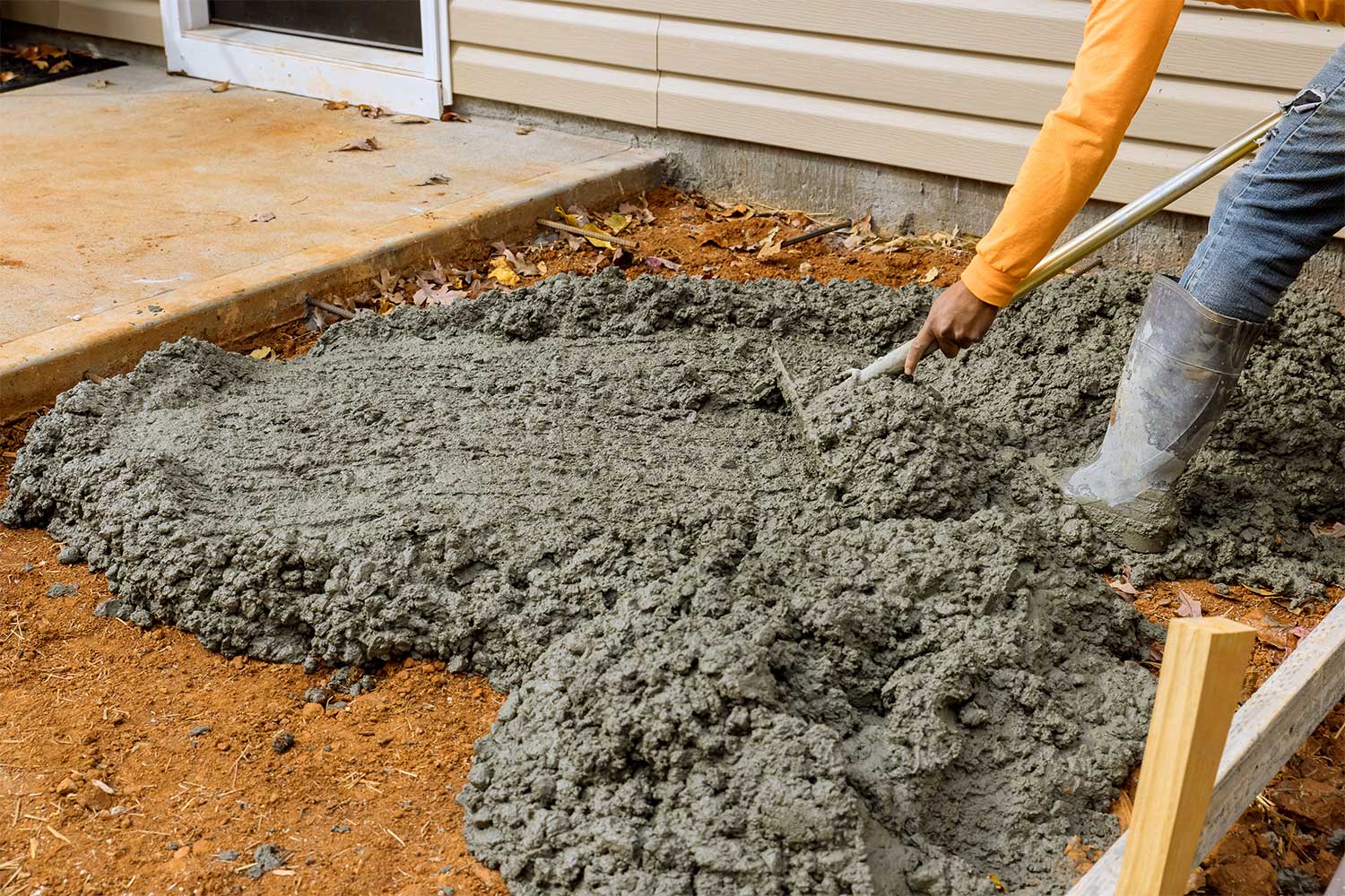 person pouring cement exterior porch